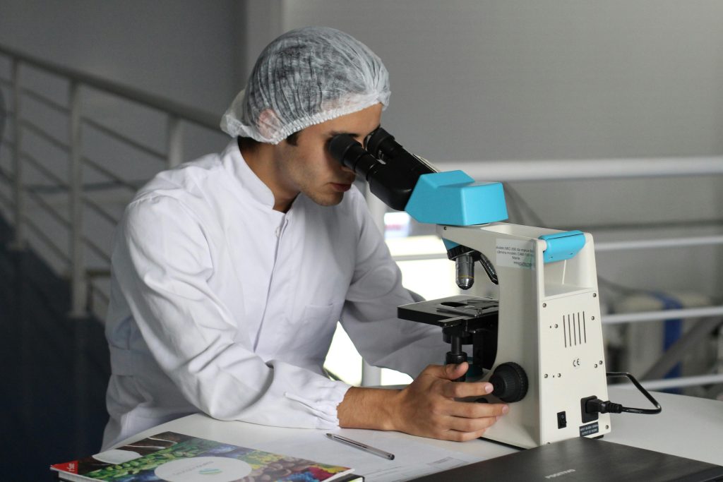 Laboratory scientist analyzing exosomes under a microscope to study cellular communication and regenerative therapy.